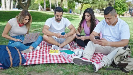 Photo for Group of people students using laptop and smartphones studying at park - Royalty Free Image