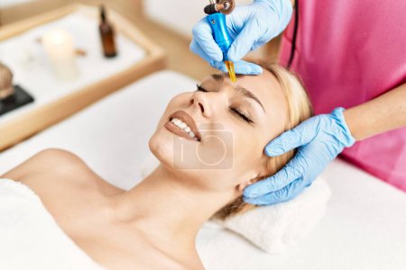 Photo for Young caucasian woman lying on table having microblading treatment at beauty salon - Royalty Free Image