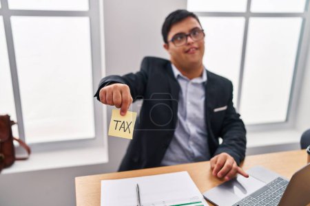 Foto de Síndrome de Down hombre trabajador de negocios retención de impuestos recordatorio de papel en la oficina - Imagen libre de derechos