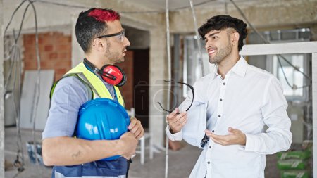 Photo for Two men builder and architect standing together speaking at construction site - Royalty Free Image