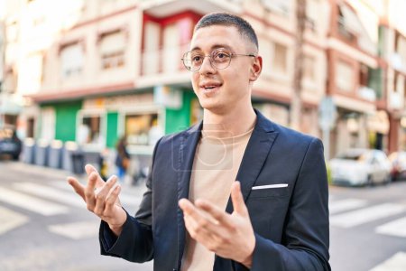 Foto de Joven hombre hispano ejecutivo sonriendo confiado hablando en la calle - Imagen libre de derechos