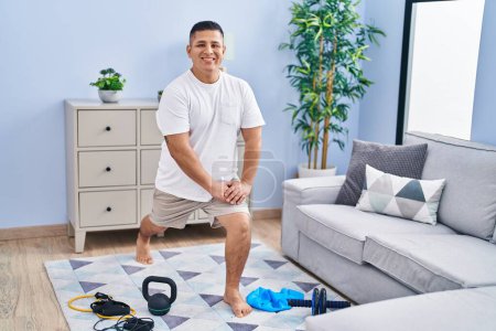 Photo for Young latin man smiling confident training leg exercise at home - Royalty Free Image