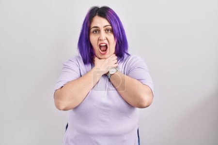 Téléchargez les photos : Plus taille femme avec les cheveux violets debout sur fond isolé crier et étouffer parce que l'étranglement douloureux. problème de santé. concept d'asphyxie et de suicide. - en image libre de droit