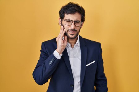 Photo for Handsome latin man standing over yellow background touching mouth with hand with painful expression because of toothache or dental illness on teeth. dentist - Royalty Free Image