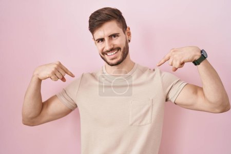 Photo for Hispanic man with beard standing over pink background looking confident with smile on face, pointing oneself with fingers proud and happy. - Royalty Free Image