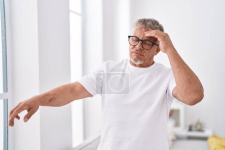 Téléchargez les photos : Middle age grey-haired man suffering dizzy standing at home - en image libre de droit