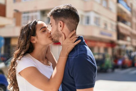 Téléchargez les photos : Jeune couple hispanique souriant confiant s'embrassant et s'embrassant dans la rue - en image libre de droit