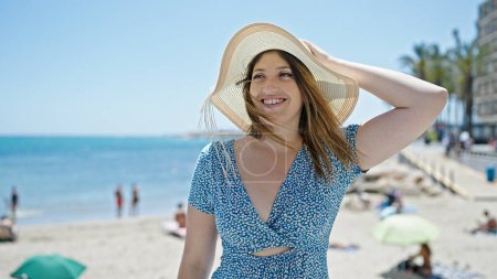 Téléchargez les photos : Jeune femme blonde touriste souriant confiance debout au bord de la mer - en image libre de droit