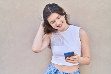 Foto de Joven mujer caucásica sonriendo confiado usando teléfono inteligente sobre fondo blanco aislado - Imagen libre de derechos