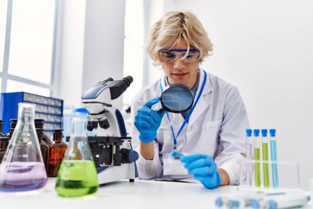 Photo for Young blond man scientist using magnifying glass at laboratory - Royalty Free Image