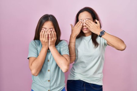 Photo for Young mother and daughter standing over pink background rubbing eyes for fatigue and headache, sleepy and tired expression. vision problem - Royalty Free Image