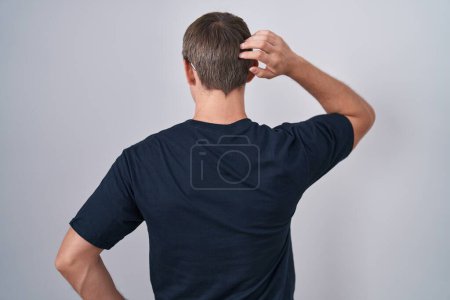 Foto de Hombre rubio caucásico con camiseta bitcoin al revés pensando en la duda con la mano en la cabeza - Imagen libre de derechos