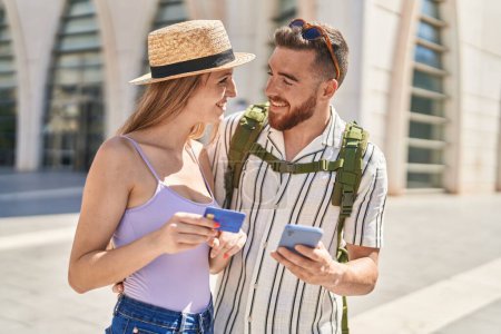 Photo for Man and woman tourist couple using smartphone and credit card at street - Royalty Free Image