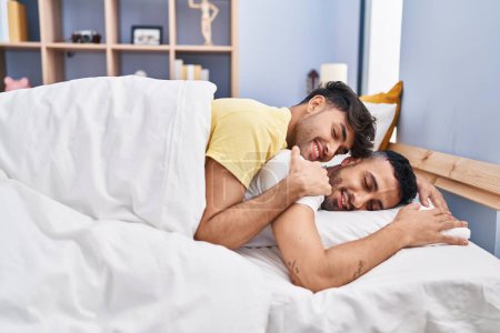 Téléchargez les photos : Deux hommes couple étreignant l'autre couché sur le lit dans la chambre - en image libre de droit