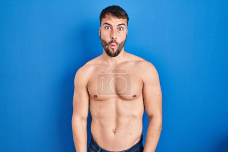 Photo for Handsome hispanic man standing shirtless making fish face with lips, crazy and comical gesture. funny expression. - Royalty Free Image
