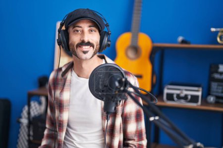 Téléchargez les photos : Jeune homme hispanique musicien souriant confiant au studio de musique - en image libre de droit