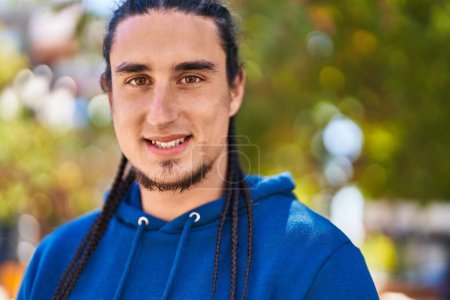 Téléchargez les photos : Jeune homme souriant confiant debout au parc - en image libre de droit