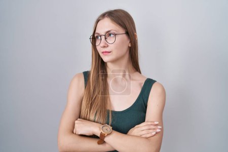 Téléchargez les photos : Jeune femme caucasienne debout sur fond blanc regardant sur le côté avec les bras croisés convaincus et confiants - en image libre de droit