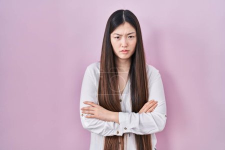 Téléchargez les photos : Jeune femme chinoise debout sur fond rose sceptique et nerveux, expression désapprobatrice sur le visage avec les bras croisés. personne négative. - en image libre de droit