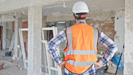 Photo for Middle age man builder standing backwards at construction site - Royalty Free Image