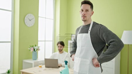 Foto de Dos hombres en pareja usando portátil haciendo tareas en el comedor - Imagen libre de derechos