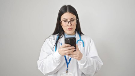 Foto de Joven doctora hispana usando smartphone sobre fondo blanco aislado - Imagen libre de derechos
