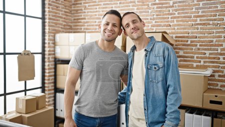Foto de Dos hombres de comercio electrónico trabajadores de negocios sonriendo confiados en la oficina - Imagen libre de derechos