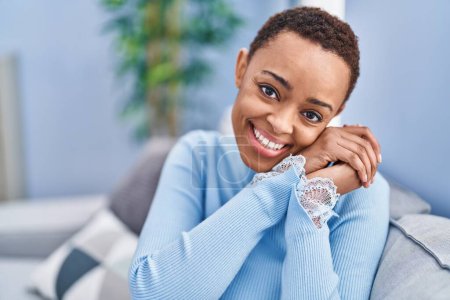 Téléchargez les photos : African american woman smiling confident sitting on sofa at home - en image libre de droit