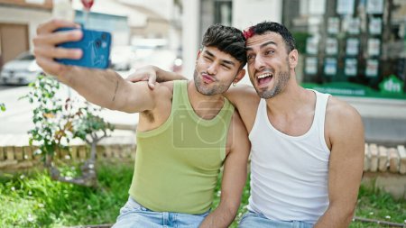 Téléchargez les photos : Deux hommes couple souriant confiant faire selfie par smartphone au parc - en image libre de droit