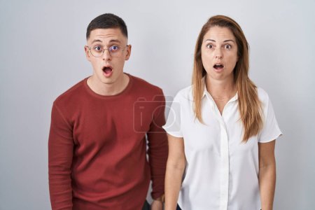 Photo for Mother and son standing together over isolated background afraid and shocked with surprise and amazed expression, fear and excited face. - Royalty Free Image