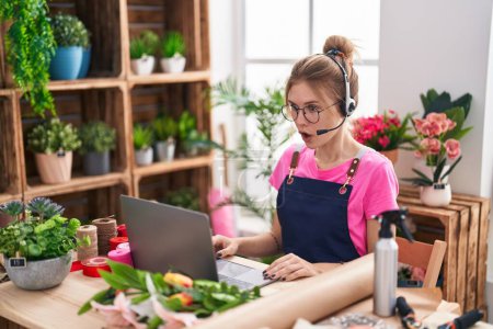 Photo for Blonde caucasian woman working at florist shop doing video call scared and amazed with open mouth for surprise, disbelief face - Royalty Free Image