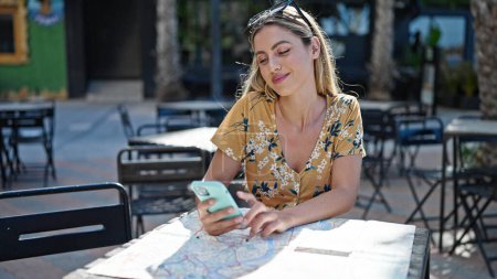 Foto de Young blonde woman smiling confident using smartphone at coffee shop terrace - Imagen libre de derechos