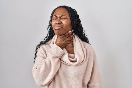 Foto de Mujer africana de pie sobre fondo blanco tocando doloroso cuello, dolor de garganta para la gripe, la clod y la infección - Imagen libre de derechos
