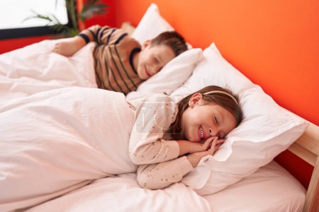 Photo for Adorable boy and girl lying on bed sleeping at bedroom - Royalty Free Image