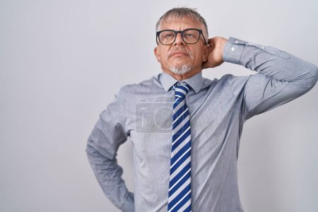 Photo for Hispanic business man with grey hair wearing glasses suffering of neck ache injury, touching neck with hand, muscular pain - Royalty Free Image