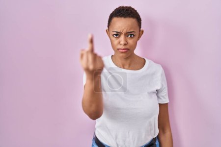 Téléchargez les photos : Beautiful african american woman standing over pink background showing middle finger, impolite and rude fuck off expression - en image libre de droit
