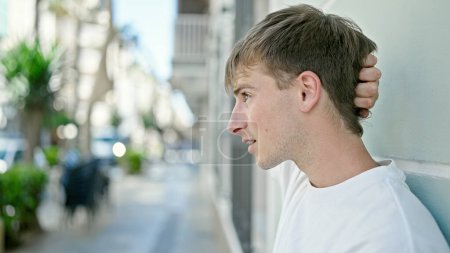 Foto de Joven hombre caucásico mirando hacia un lado con expresión seria en la calle - Imagen libre de derechos