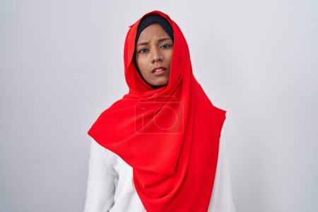 Photo for Young arab woman wearing traditional islamic hijab scarf looking sleepy and tired, exhausted for fatigue and hangover, lazy eyes in the morning. - Royalty Free Image