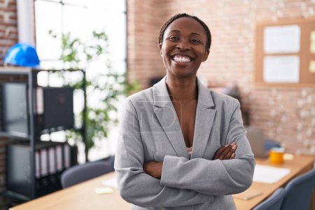 Téléchargez les photos : Femme afro-américaine au bureau heureux visage souriant avec les bras croisés en regardant la caméra. personne positive. - en image libre de droit