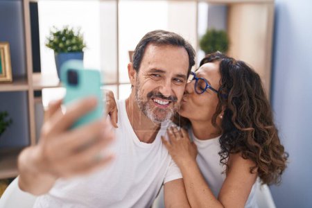 Téléchargez les photos : Man and woman couple make selfie by smartphone sitting on table at home - en image libre de droit
