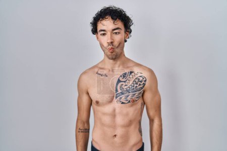 Photo for Hispanic man standing shirtless making fish face with lips, crazy and comical gesture. funny expression. - Royalty Free Image