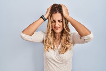 Photo for Young blonde woman standing over isolated background suffering from headache desperate and stressed because pain and migraine. hands on head. - Royalty Free Image