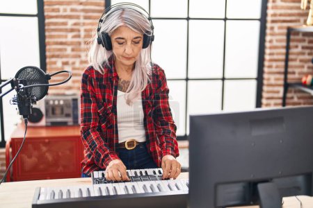 Foto de Músico de pelo gris de mediana edad tocando el piano en el estudio de música - Imagen libre de derechos