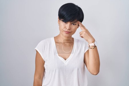 Photo for Young asian woman with short hair standing over isolated background shooting and killing oneself pointing hand and fingers to head like gun, suicide gesture. - Royalty Free Image