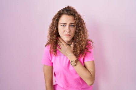 Photo for Young caucasian woman standing over pink background cutting throat with hand as knife, threaten aggression with furious violence - Royalty Free Image