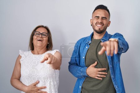 Photo for Hispanic mother and son standing together laughing at you, pointing finger to the camera with hand over body, shame expression - Royalty Free Image