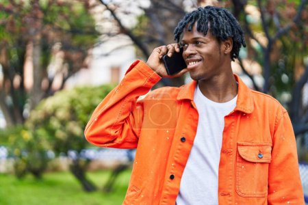 Téléchargez les photos : African american man smiling confident talking on the smartphone at park - en image libre de droit