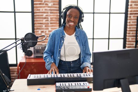 Foto de Músico afroamericano tocando el teclado de piano en el estudio de música - Imagen libre de derechos