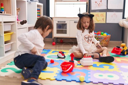 Photo for Adorable boy and girl playing supermarket game sitting on floor at kindergarten - Royalty Free Image