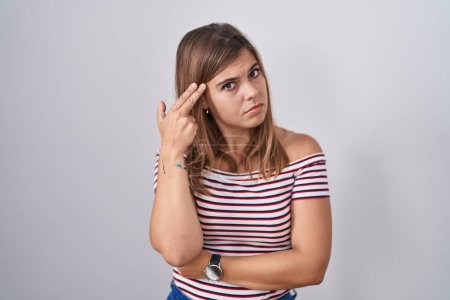 Photo for Young hispanic woman standing over isolated background shooting and killing oneself pointing hand and fingers to head like gun, suicide gesture. - Royalty Free Image